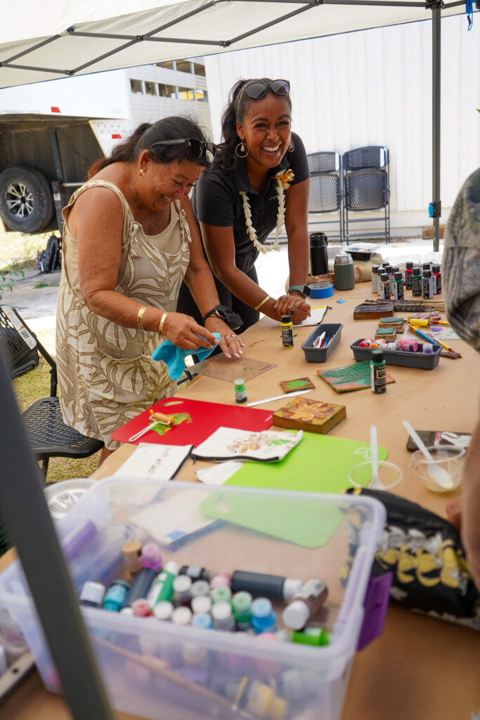 Two attendees share laughs while stamping.
